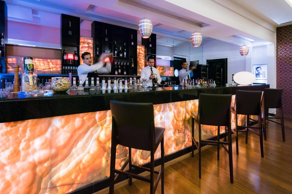a bar in a restaurant with people standing at it at Savoy Le Grand Hotel Marrakech in Marrakesh