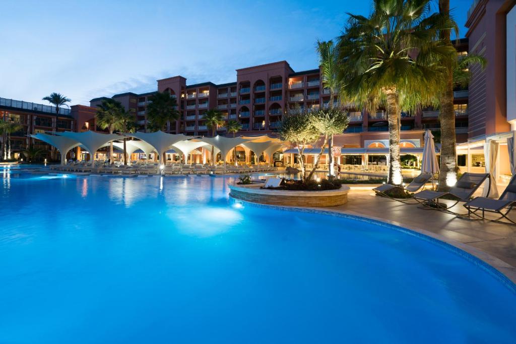 a large swimming pool in front of a hotel at Savoy Le Grand Hotel Marrakech in Marrakesh