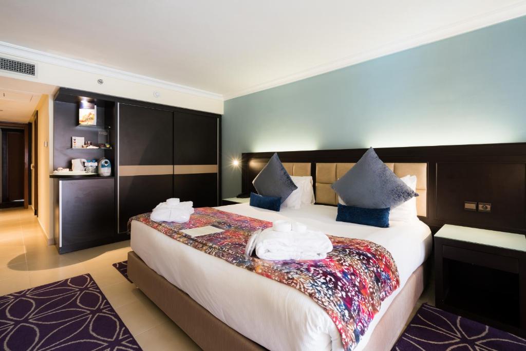 a hotel room with a bed with towels on it at Savoy Le Grand Hotel Marrakech in Marrakesh