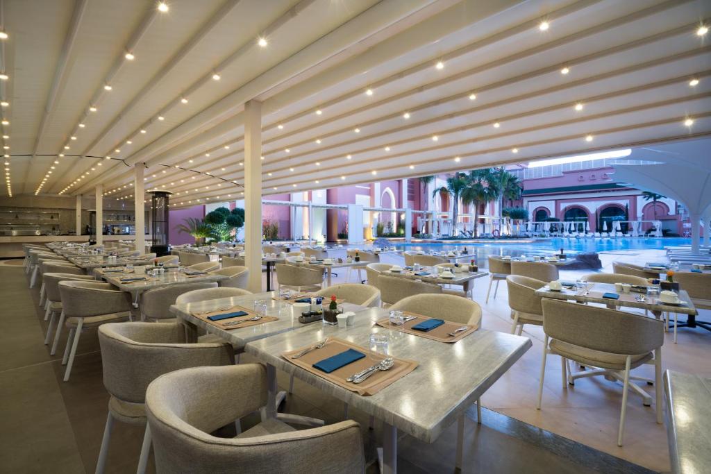 a dining room with tables and chairs in a restaurant at Savoy Le Grand Hotel Marrakech in Marrakesh