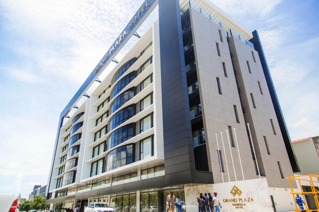 a tall building with people standing outside of it at Grand Plaza Hotel Nampula in Nampula