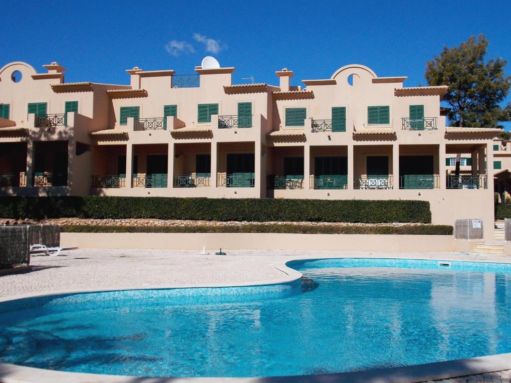 - un grand bâtiment avec une piscine en face dans l'établissement Charming Villa Albufeira, à Albufeira