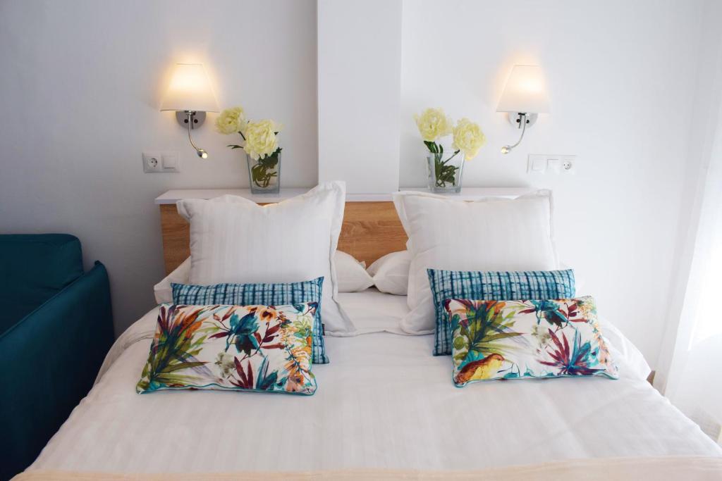 een slaapkamer met 2 bedden met witte lakens en tropische kussens bij Nevada 3-23 in Nerja
