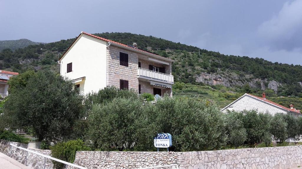 a house on top of a hill with a sign at Apartments Tonka in Bol