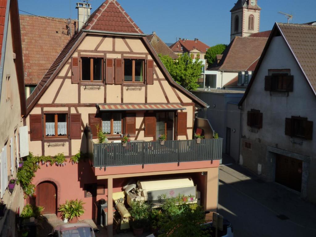 een oud huis met een balkon in een stad bij Gaby et Georges in Beblenheim