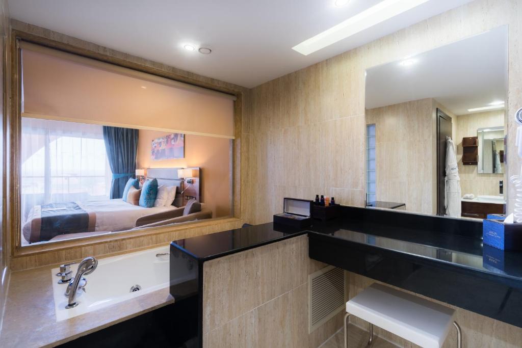 a bathroom with a sink and a large mirror at Savoy Le Grand Hotel Marrakech in Marrakesh