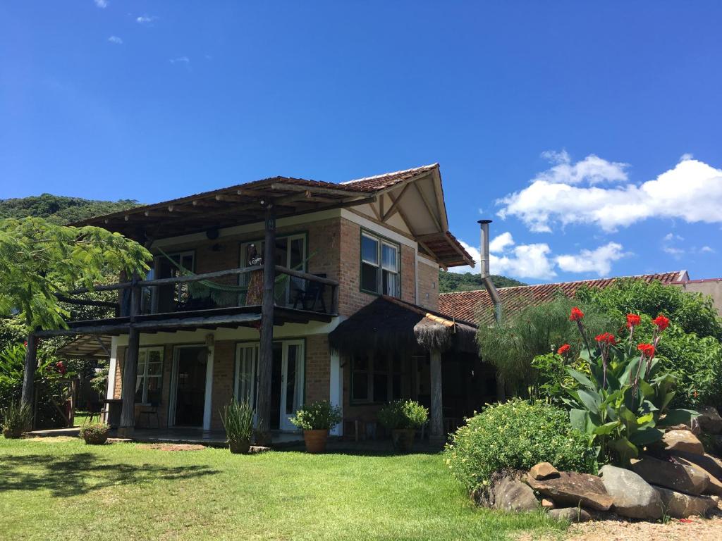 a brick house with a balcony on a yard at Recanto Praia do Forte - SC in São Francisco do Sul