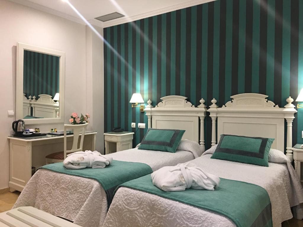 um quarto com 2 camas e toalhas em Adriano Boutique Sevilla em Sevilha