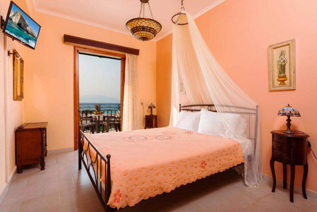 a bedroom with a bed with a view of the ocean at Photographer's Apartments in Alikanas