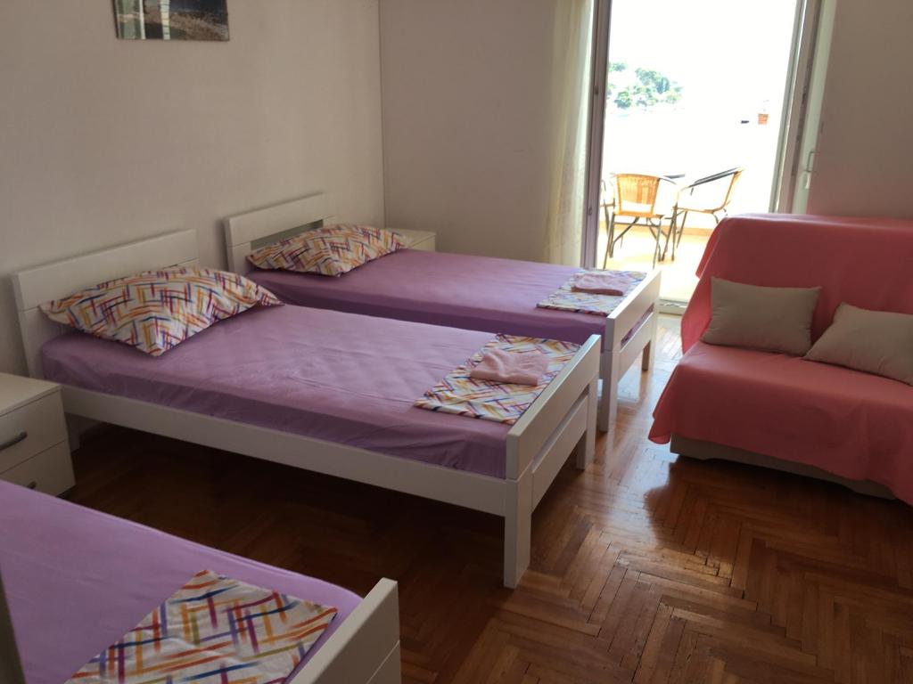 una camera con due letti e un divano di GORAN'S PLACE a Hvar