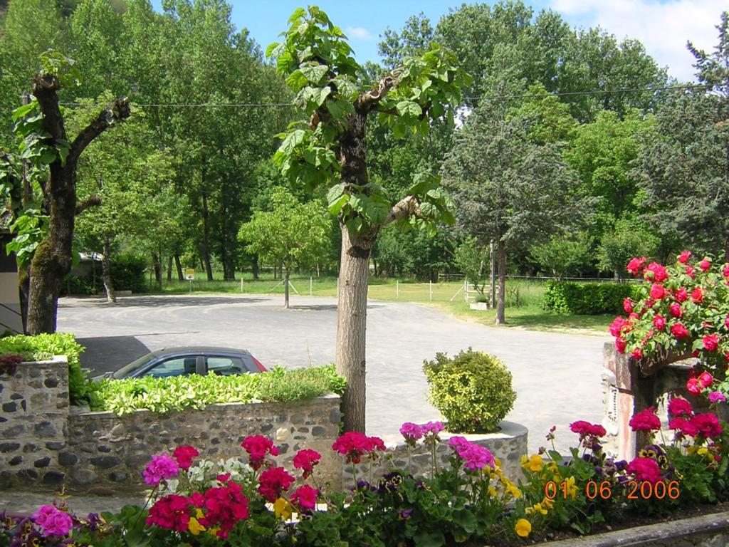 un coche aparcado en un estacionamiento con flores en Le Relais de Boralde, en Espalion