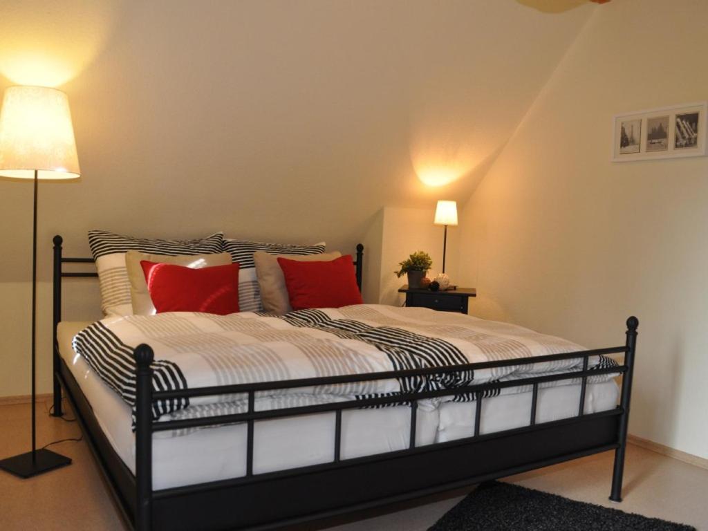 ein Schlafzimmer mit einem großen Bett mit roten Kissen in der Unterkunft Seespatz in Diemelsee