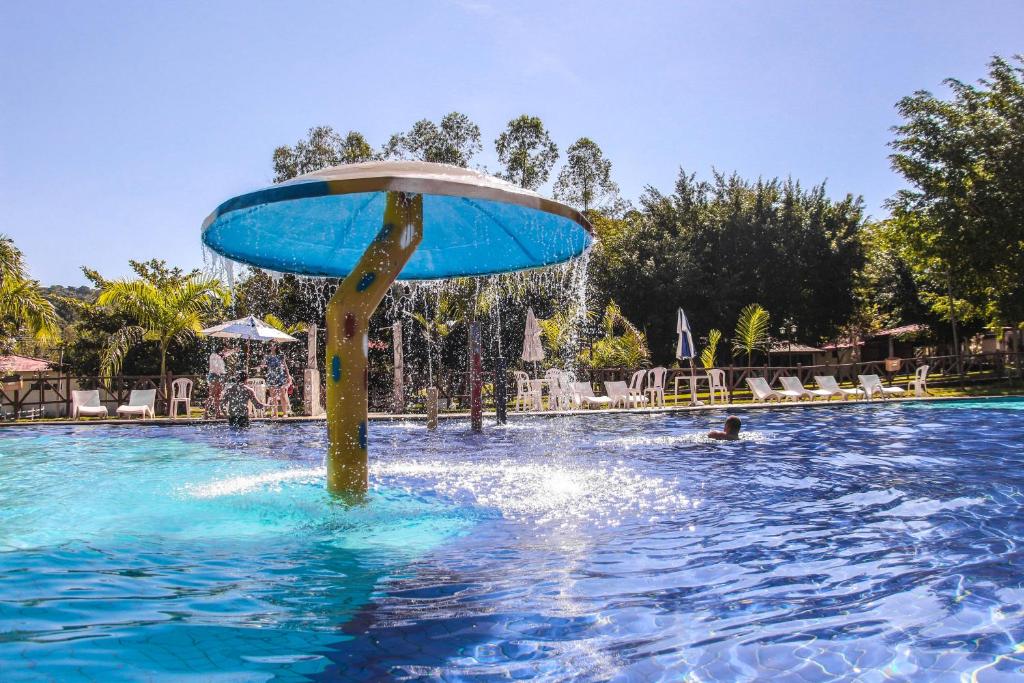 uma piscina com uma fonte no meio dela em Hotel Fazenda Chiminelli em Cachoeiras de Macacu