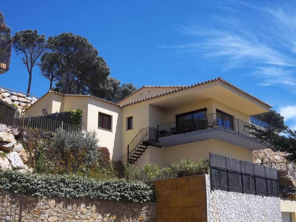 a white house on a hill with a fence at Villa Hermosa in Begur