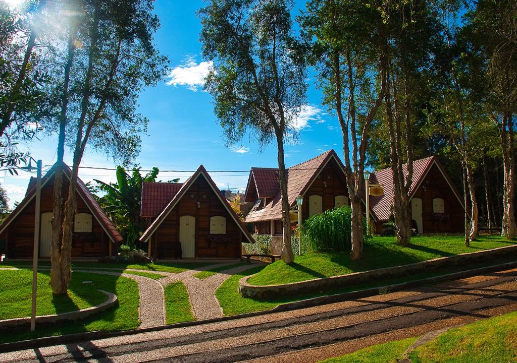 a row of houses with trees and grass at Mirágua Refugios Pousada in Brotas