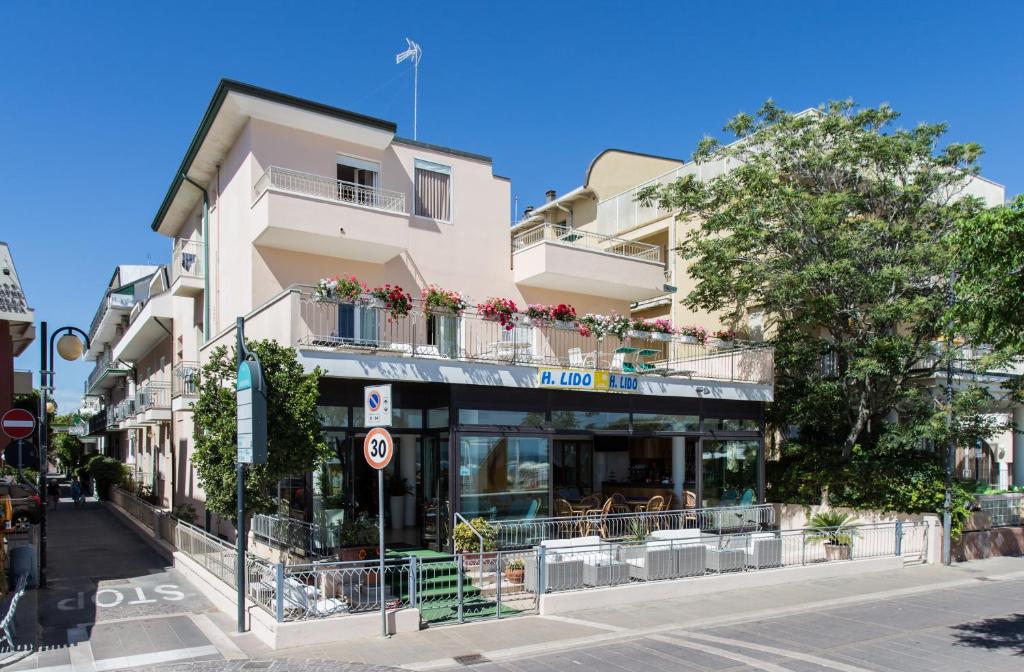 un bâtiment avec un restaurant dans une rue de la ville dans l'établissement Hotel Lido, à Bellaria-Igea Marina