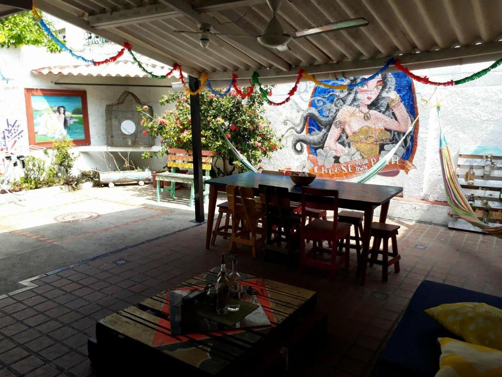a patio with a table and chairs and a mural at Casa Aluna in Barranquilla