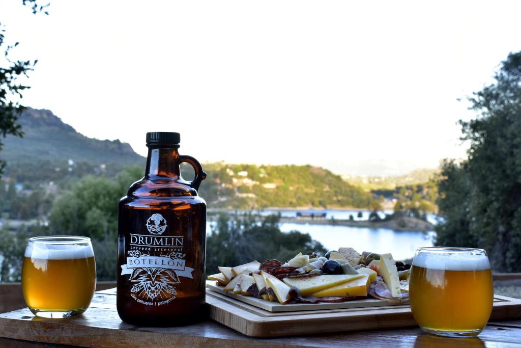 una botella de cerveza y un plato de comida en una mesa en Cabañas Agua Clara en Villa Pehuenia