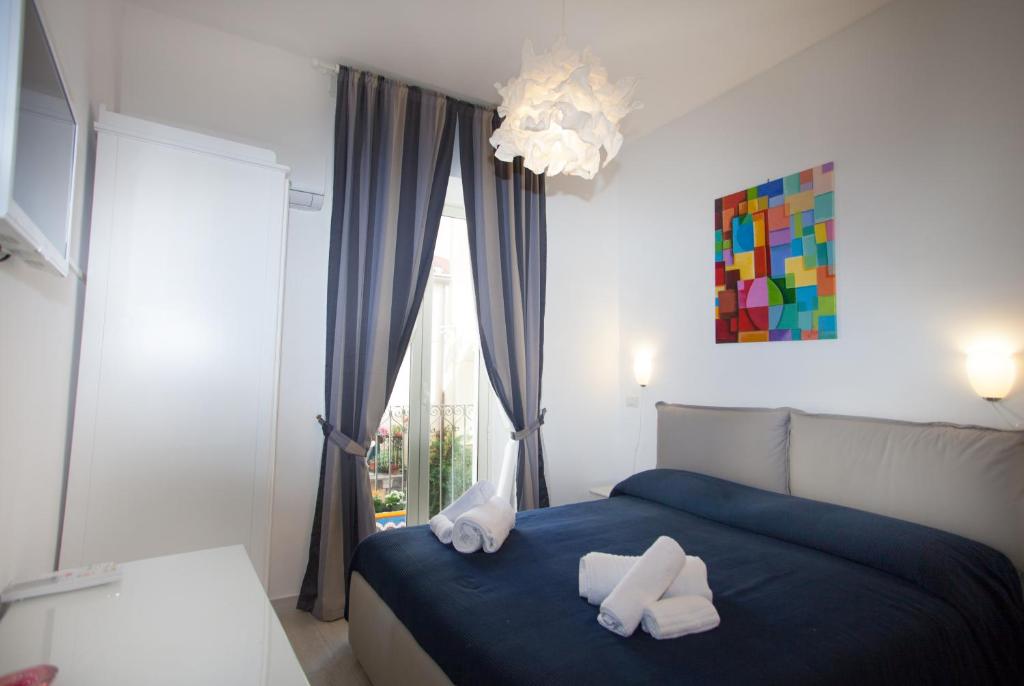 una camera da letto con un letto blu e asciugamani di Casa Don Micio a Taormina