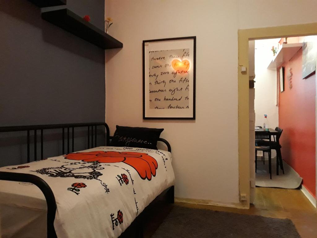 リスボンにあるFamilly Cottageのベッドルーム1室(ベッド1台付)が備わります。壁に絵が飾られています。