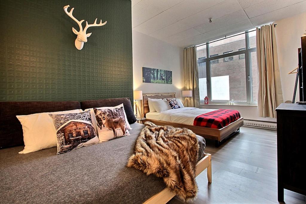 um quarto com uma cama, um sofá e uma janela em INITIAL - LOFT FORESTIER - Centre-Ville de Québec em Quebeque