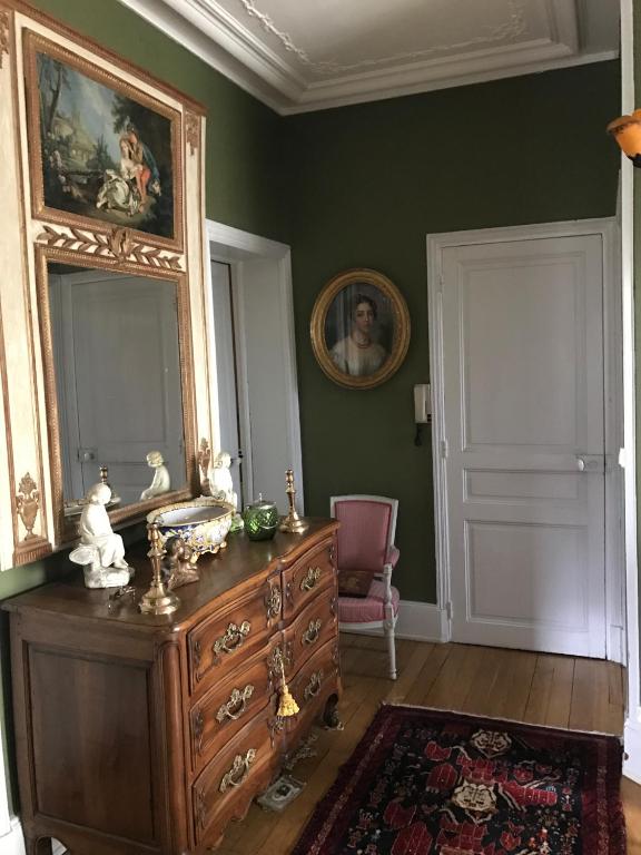 un salon avec une commode et un miroir dans l'établissement Chez Auguste, à Nancy