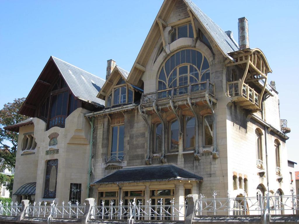 un grande edificio in pietra con balcone di Chez Auguste a Nancy