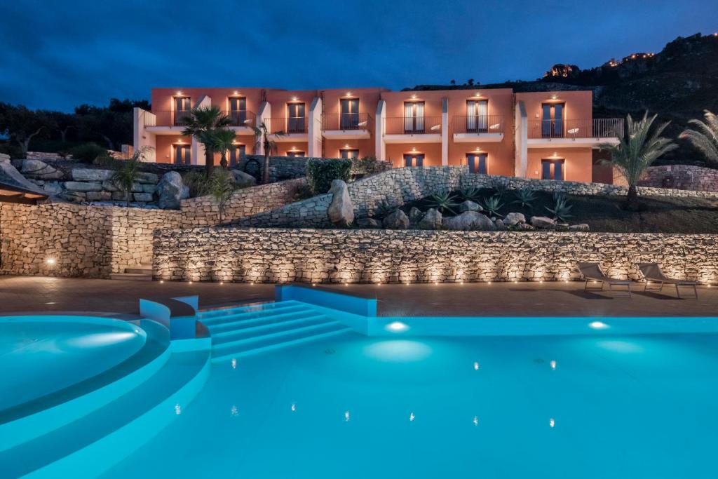 uma casa com piscina em frente a um edifício em Hotel Parco Degli Aromi Resort & SPA em Valderice