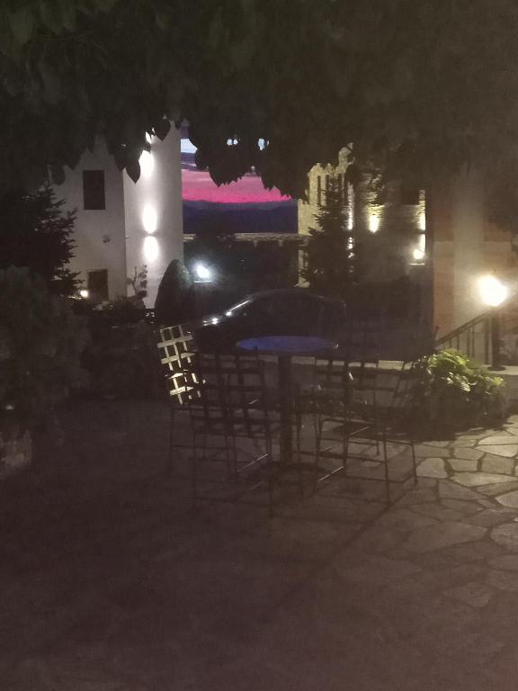 stół i krzesła na dziedzińcu w nocy w obiekcie Guesthouse Kolenti w mieście Portariá