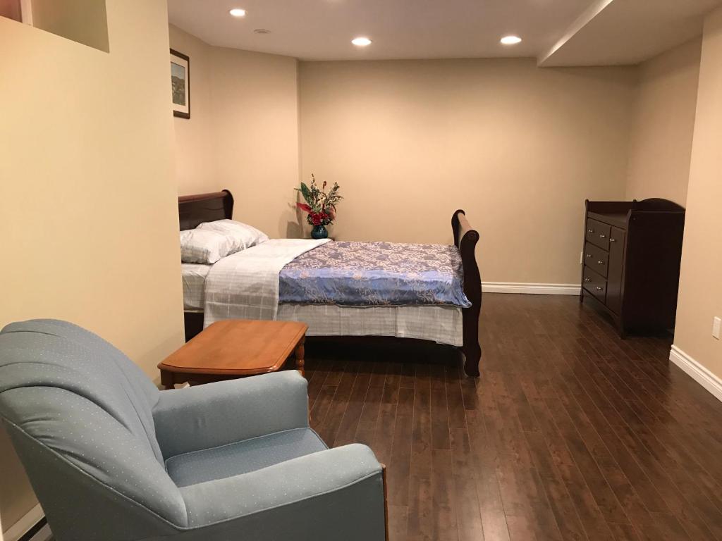 a bedroom with a bed and a couch and a chair at Sweet home in Moncton