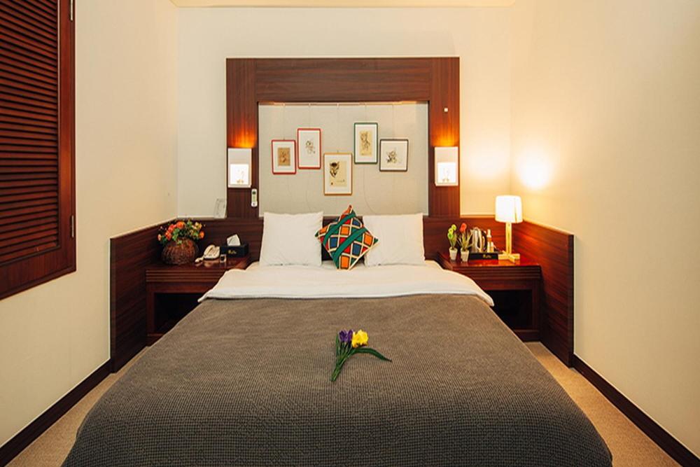 仁川的住宿－Incheon Airporthotel Airstay，一间卧室配有一张大床,床上放着鲜花