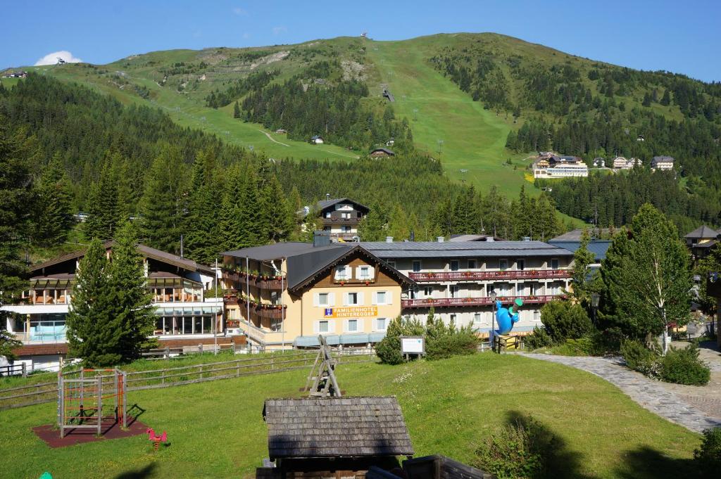un gran edificio con una montaña en el fondo en Familienhotel Hinteregger en Katschberghöhe