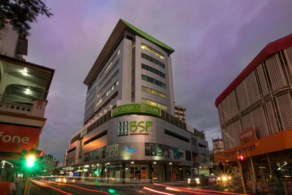 a tall building on a city street at night at Quest Suva in Suva