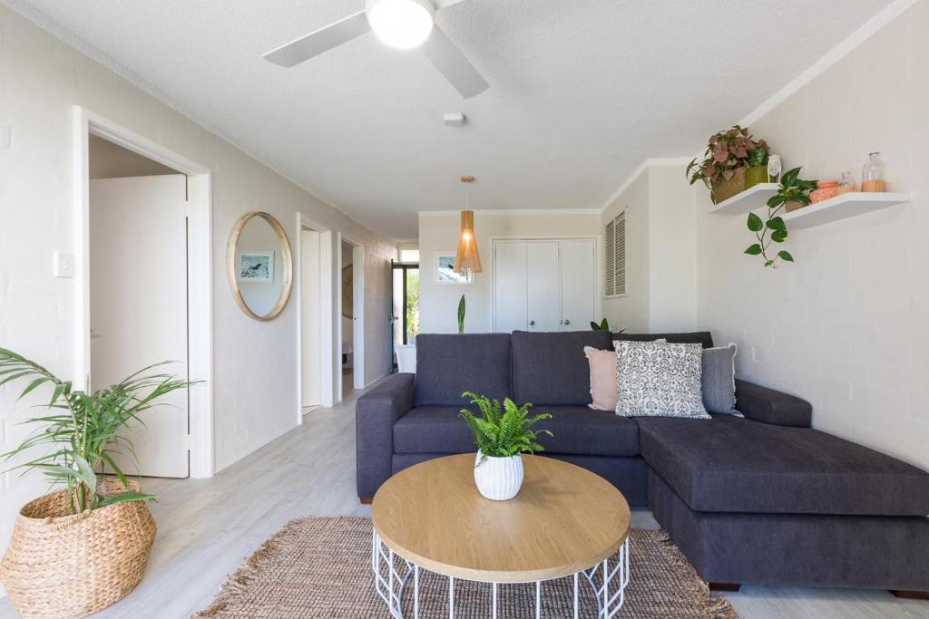 a living room with a blue couch and a table at Number 72 Kalbarri Riverview Apartments in Kalbarri