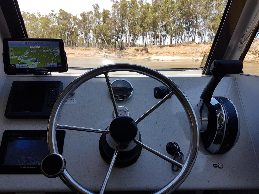 ein Armaturenbrett mit einem Lenkrad und einem Tablet in der Unterkunft Moama on Murray Houseboats in Moama