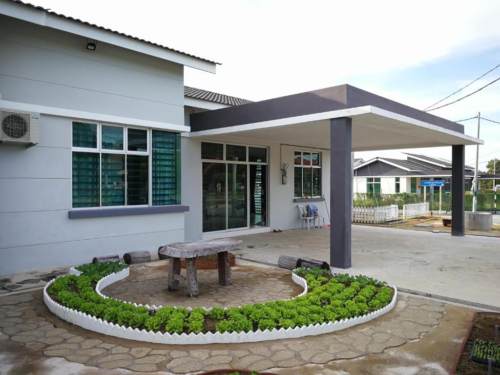 a house with a bench in front of it at Greenery Garden Concept Homestay in Kuantan