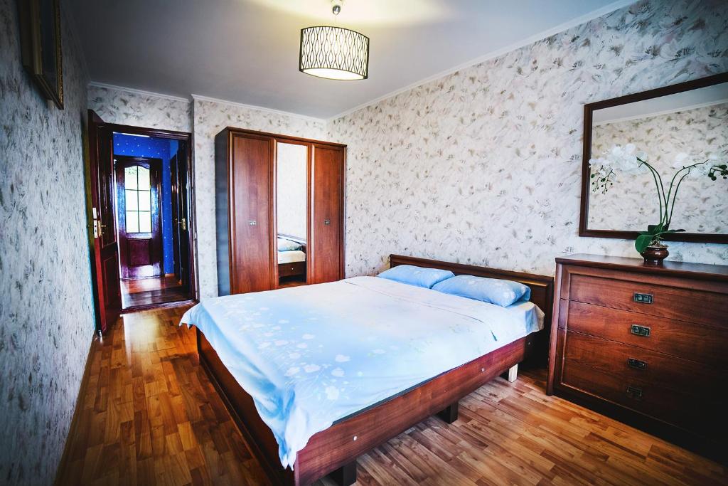 a bedroom with a bed and a dresser and a mirror at 2-bedroom on Mykolaychuka street in Vinnytsya