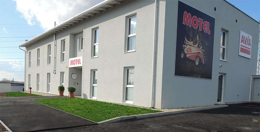 a white building with a sign on the side of it at AVIA Motel Bisamberg in Korneuburg