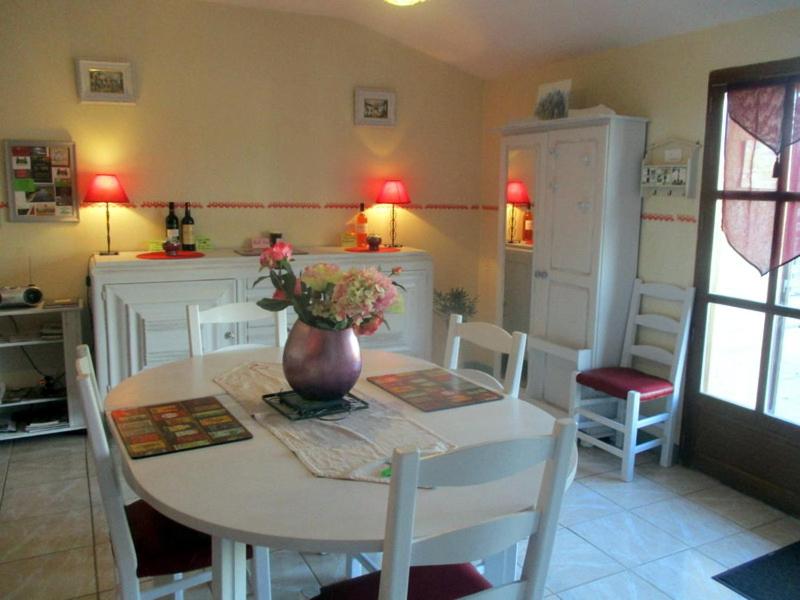 a kitchen with a table with a vase of flowers on it at Gite du Grand-Pas in Doulezon