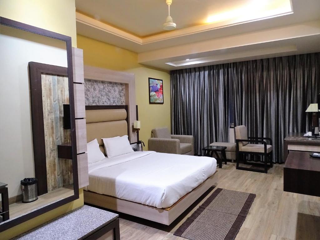 a hotel room with a bed and a desk at Hotel Continental Blue in Bikaner