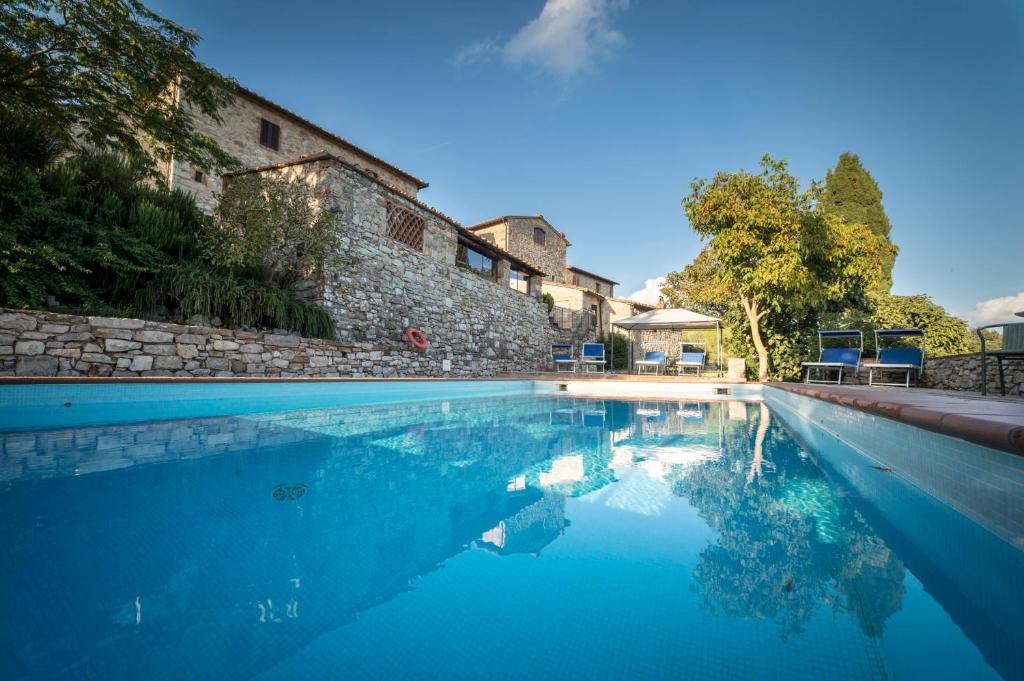 una piscina di fronte a un edificio di Collelungo a Castellina in Chianti