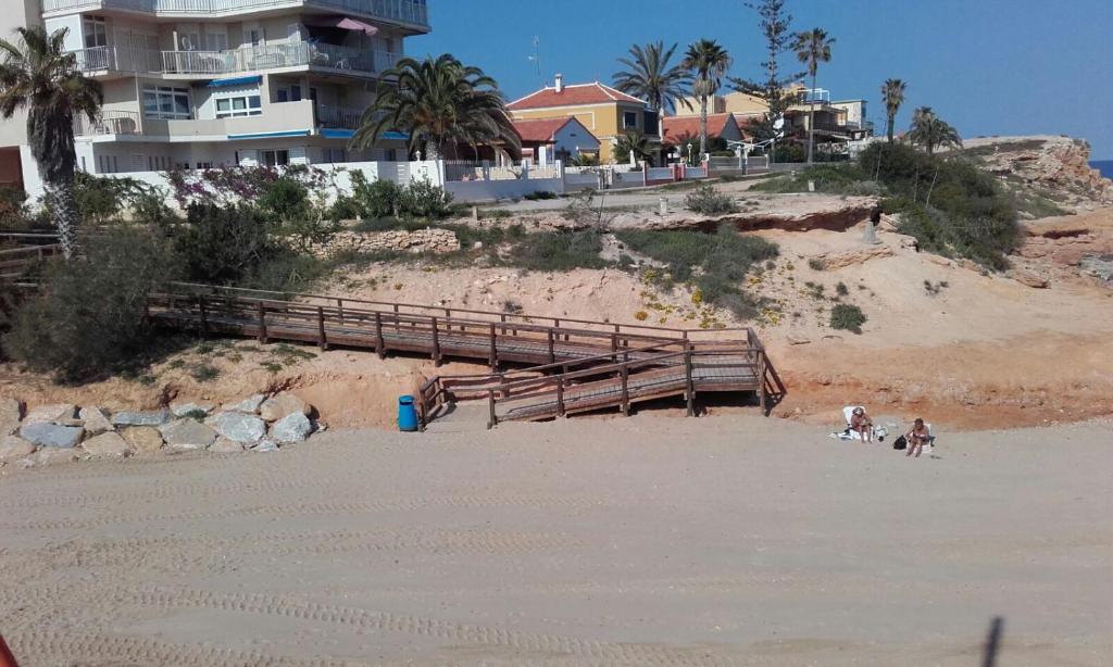 een paar mensen en een hond op een strand bij Bungalow frente al mar in Torrevieja