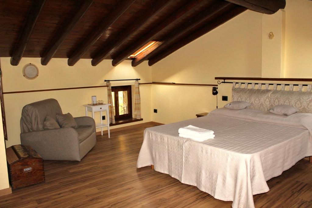 una camera con un grande letto e una sedia di Le Fiorini a Gargnano