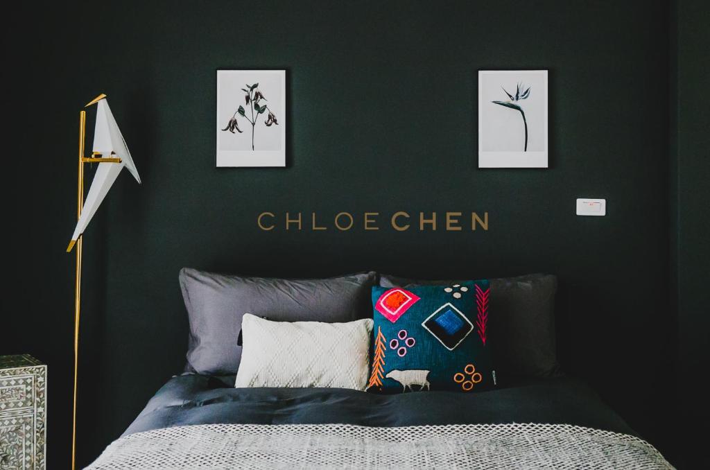 ein Schlafzimmer mit einer dunkelgrünen Wand und einem Bett in der Unterkunft Chloechen Home in Taitung