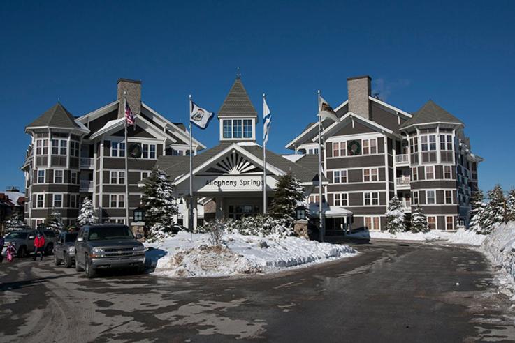 a large building with a car parked in front of it at Allegheny Springs in Snowshoe