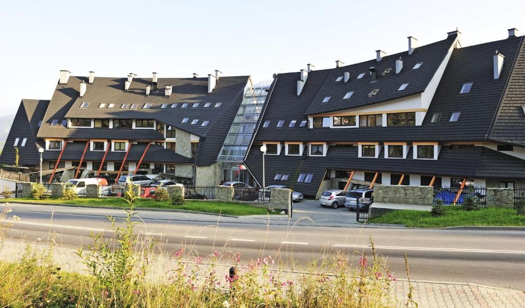 ein Gebäude mit vielen Fenstern neben einer Straße in der Unterkunft Butorowy Residence in Kościelisko