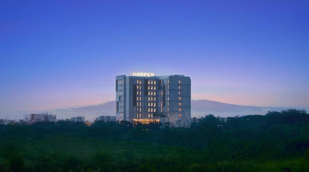 a tall building with lights on top of it at Harper Cikarang by ASTON in Cikarang