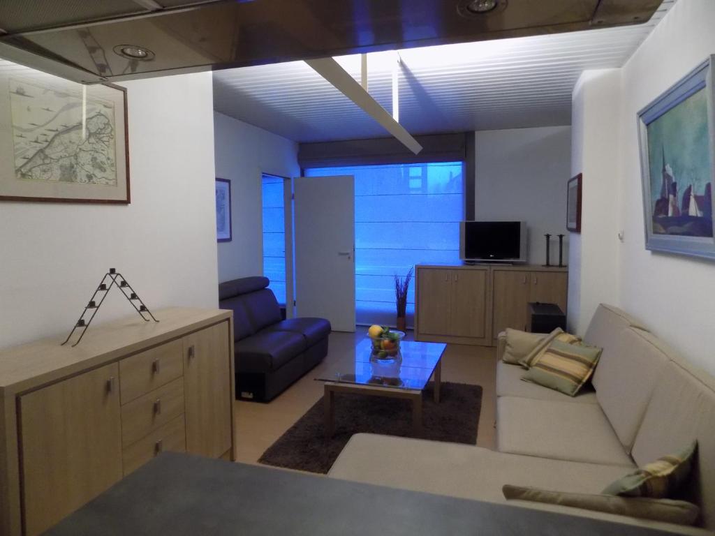 a living room with a couch and a table at Akropolis odk in Koksijde