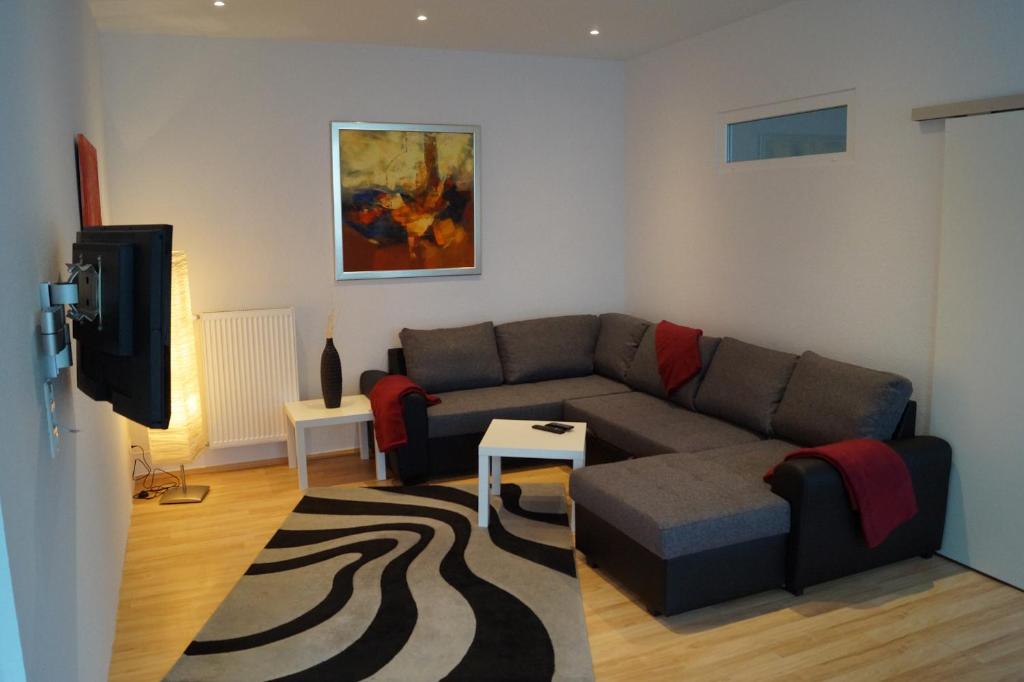uma sala de estar com um sofá e uma televisão em Ferienwohnung Übach Palenberg Marktplatz em Übach-Palenberg