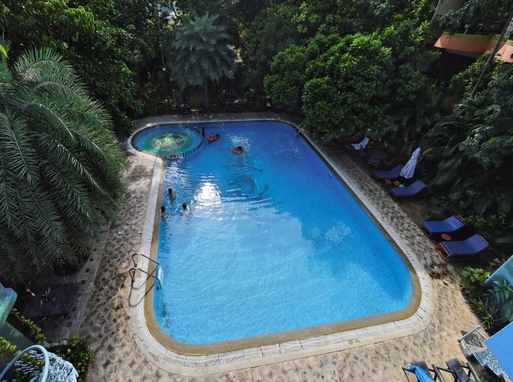een uitzicht over een zwembad met mensen erin bij Hotel Mahabs in Mahabalipuram
